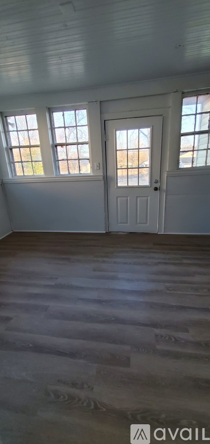 A room with a white door and windows.