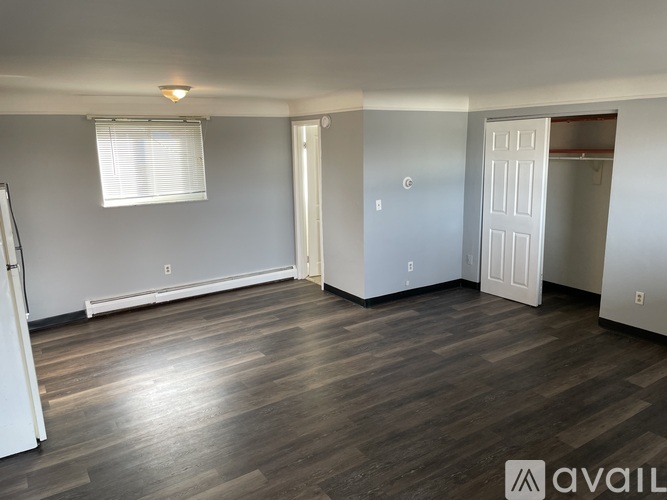 A room with wooden flooring and white walls.