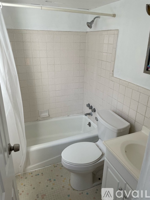 A white toilet sits next to a bathtub in a bathroom.