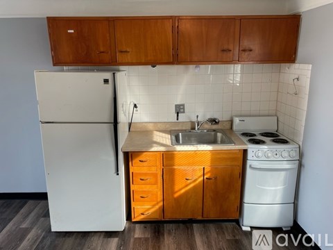 A kitchen with wooden cabinets and a white fridge.