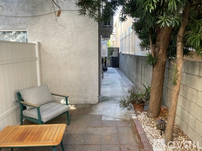 A patio with a wooden table and a green chair.