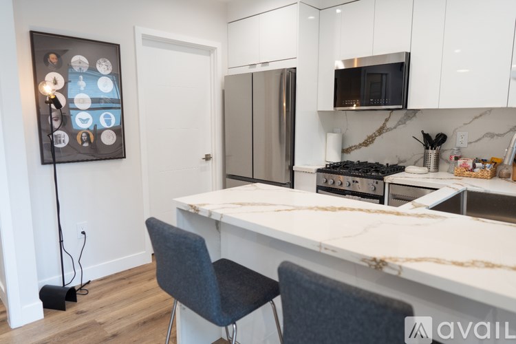 A kitchen with a white countertop and a fridge.