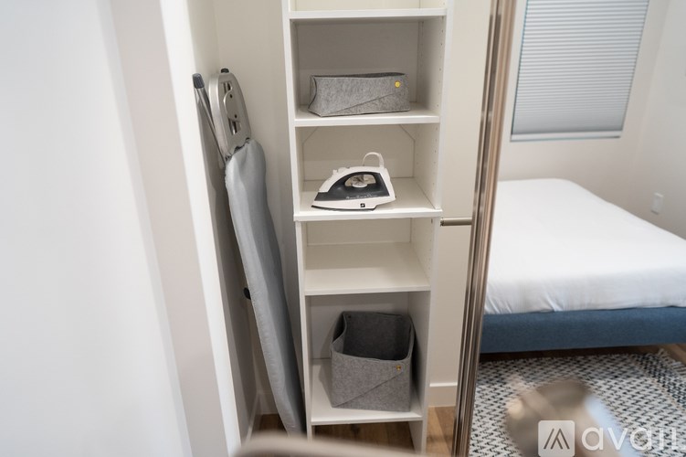 A white shelf unit with a white iron on it.