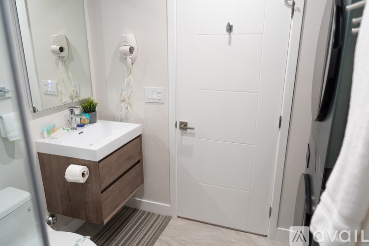 A bathroom with a toilet, sink, and mirror.