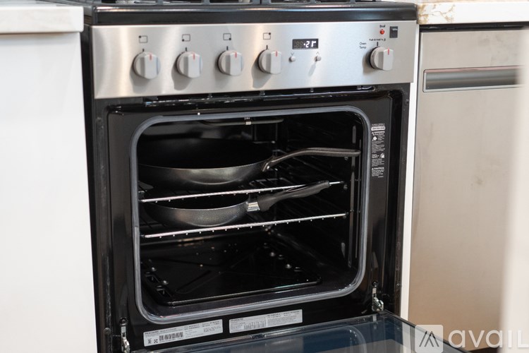A stainless steel oven with the door open showing the interior.