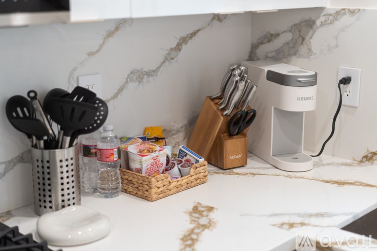 A kitchen counter with a basket of utensils and a coffee maker.