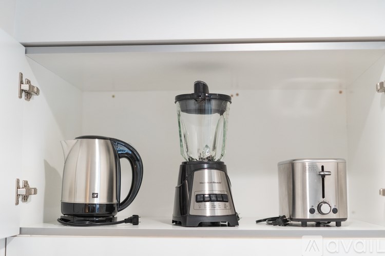 A kitchen shelf with a kettle, a blender, and a toaster.