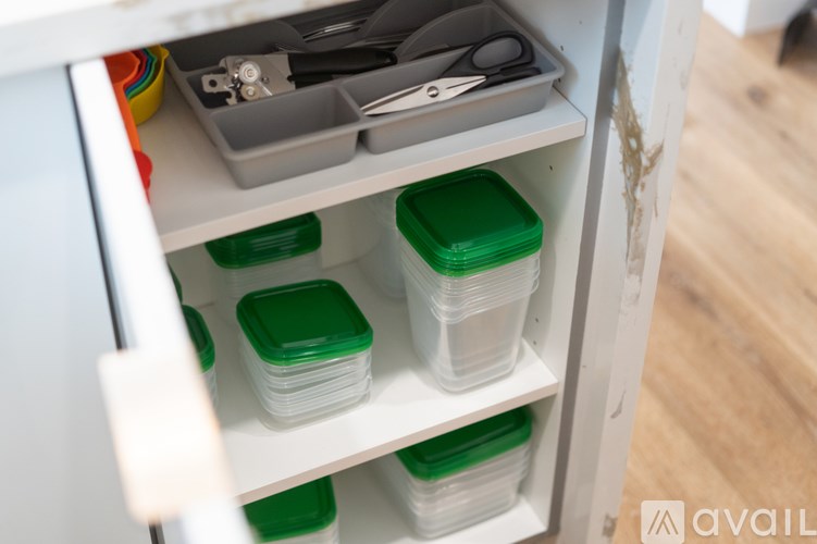 A drawer with containers and a pair of scissors.