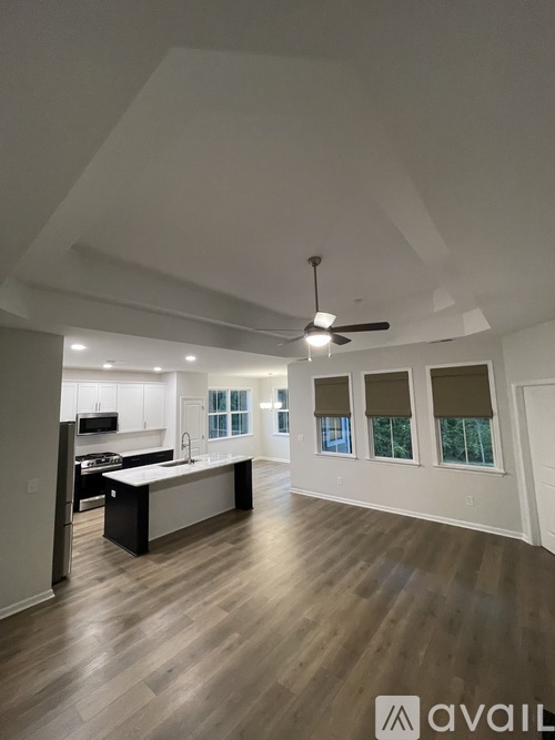 A spacious kitchen with white cabinets and a black island.