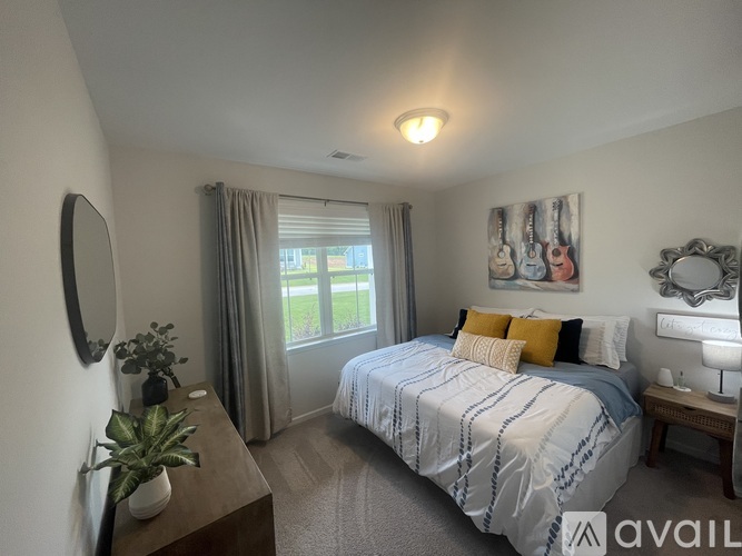 A bedroom with a bed, nightstand, and window.