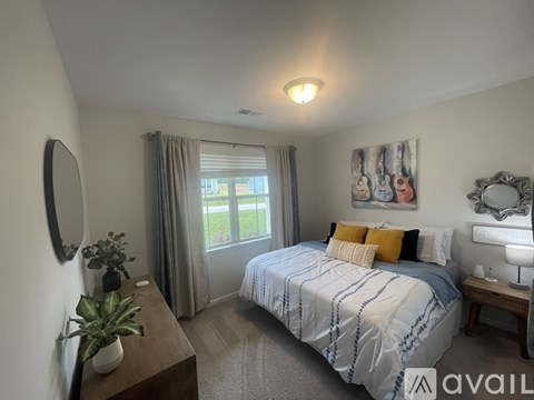 A bedroom with a bed, nightstand, and window.