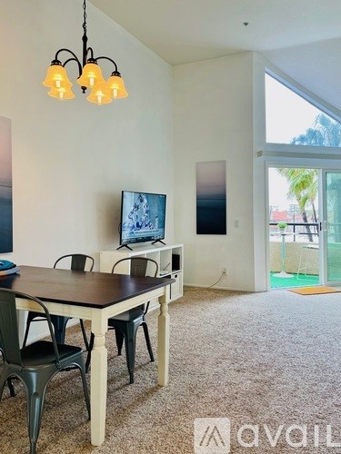 A dining room with a table and chairs and a television.