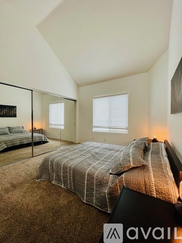 A bedroom with a large bed and a mirror on the wall.