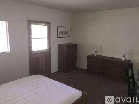 A bedroom with a bed, dresser, and nightstand.