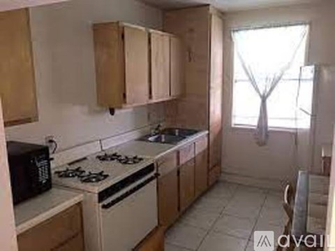 A kitchen with a stove, microwave, and cabinets.