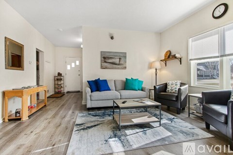 A living room with a grey couch, a coffee table, and a painting on the wall.