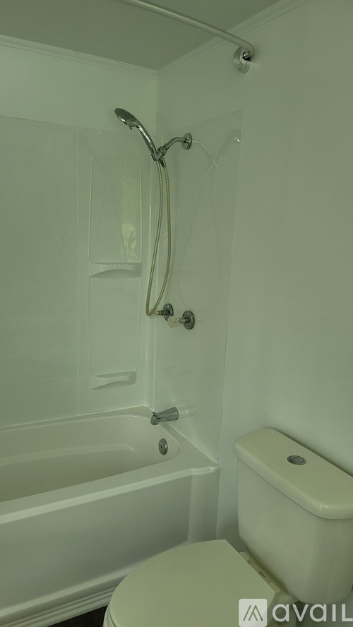 A white bathroom with a tub, toilet and shower.