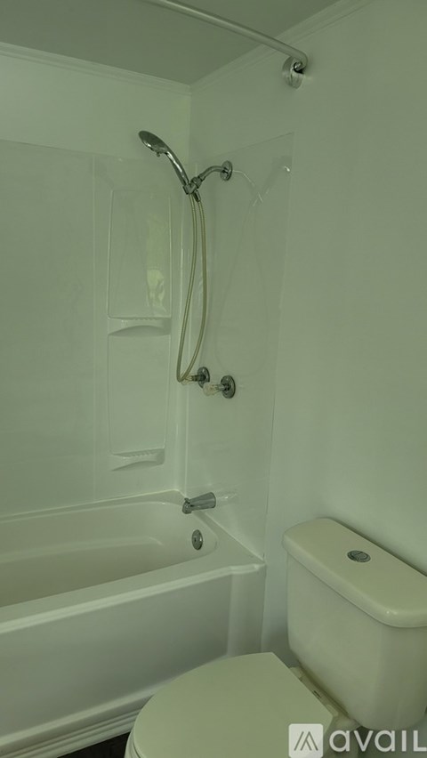 A white bathroom with a tub, toilet and shower.