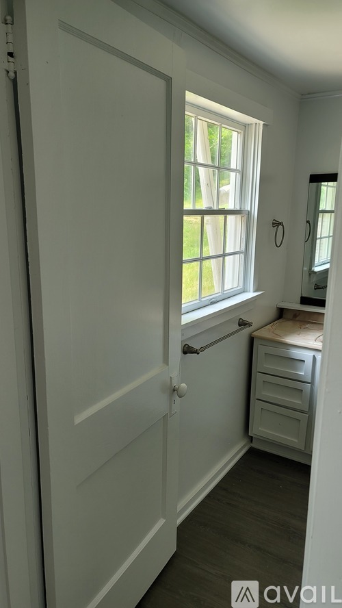 A white door with a window above a white dresser.