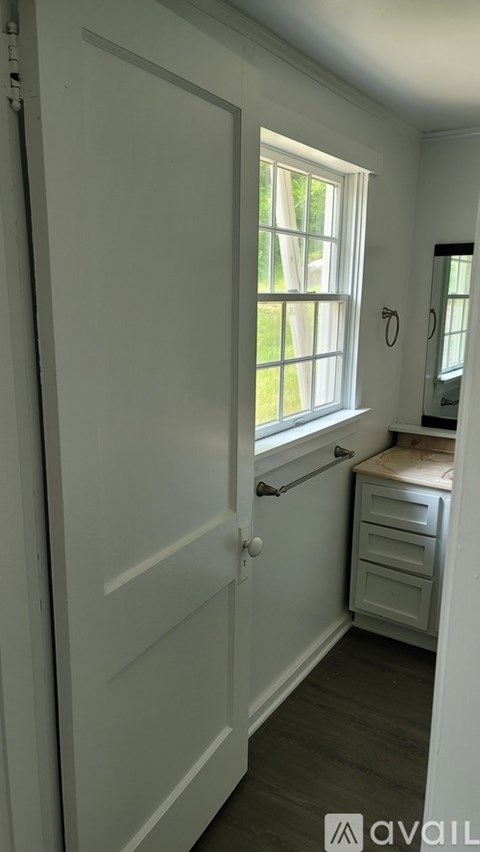 A white door with a window above a white dresser.