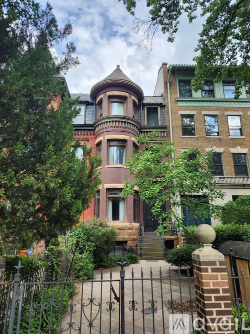 A house with a tower and a gate in front.