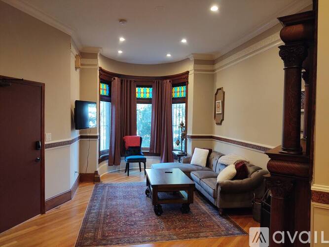 A living room with a couch, chair, and television.
