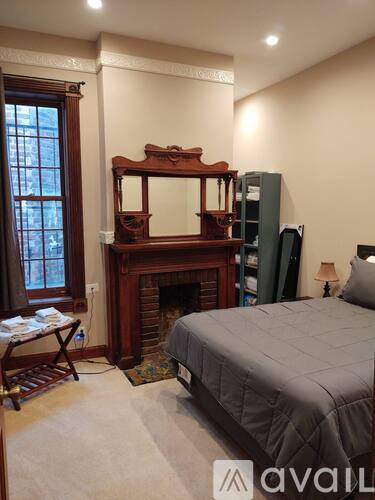A bedroom with a large bed and a fireplace.