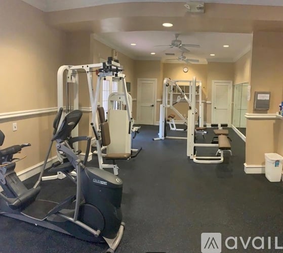 A gym with a variety of equipment including treadmills, weights, and a bench press.