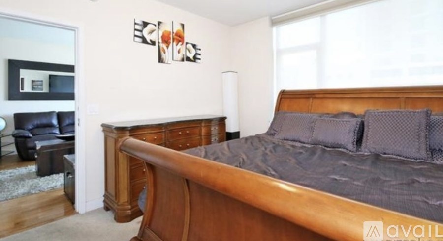 A bedroom with a large bed and a wooden headboard.