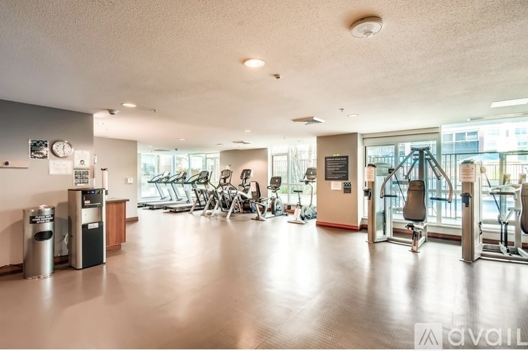 A gym with a variety of equipment including treadmills, weights, and exercise machines.