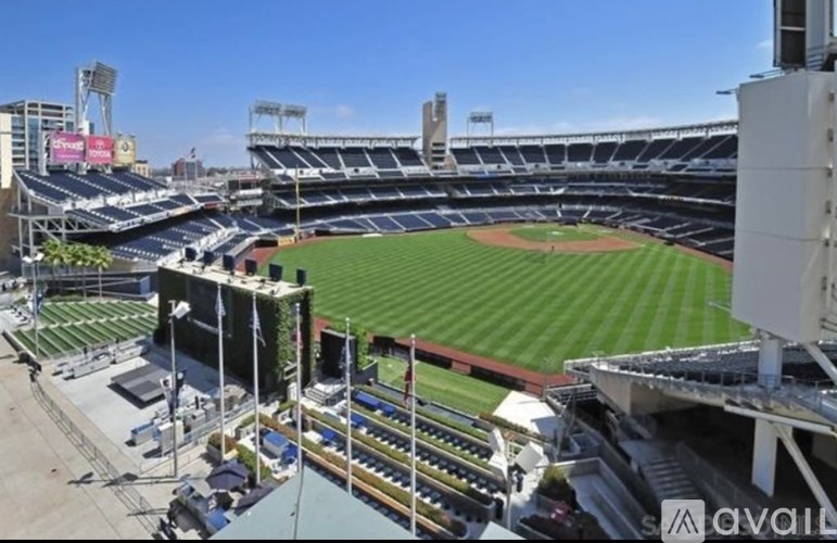 A baseball stadium is shown with a green field and empty stands.