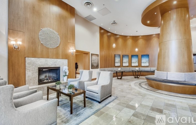 A living room with a fireplace and a large circular window.
