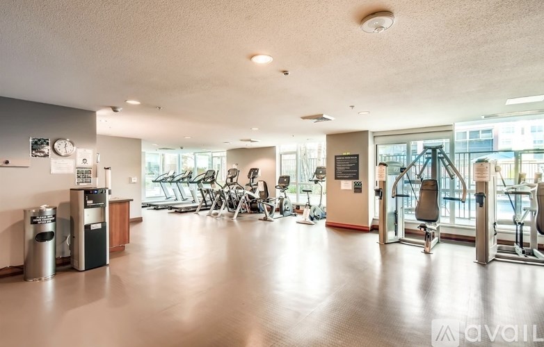 A gym with a variety of equipment including treadmills, weights, and exercise machines.