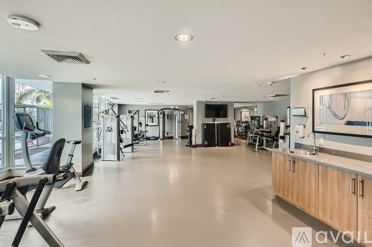 A spacious gym with a variety of equipment and a large mirror on the wall.