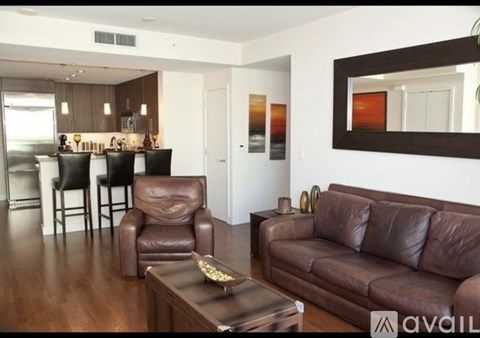 A living room with brown leather furniture and a mirror on the wall.