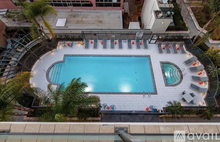 An aerial view of a pool surrounded by palm trees and lounge chairs.