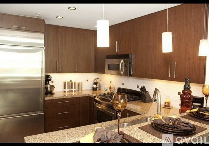 A modern kitchen with brown cabinets and a granite countertop.