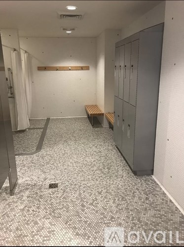 A long hallway with a bench and lockers.