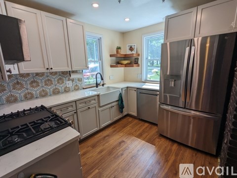 A kitchen with a stove top oven and a refrigerator.