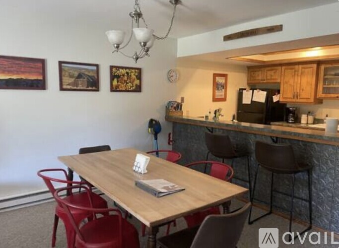 A dining area with a wooden table and red chairs.