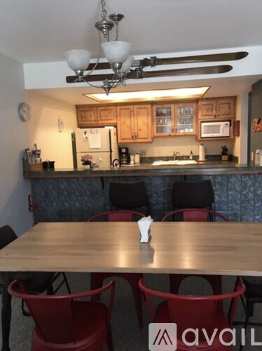 A kitchen with a table and chairs in front of it.