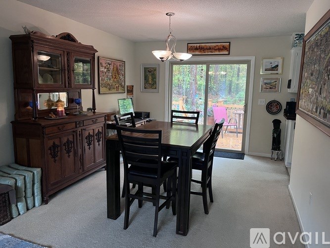 A dining room with a wooden table and chairs.