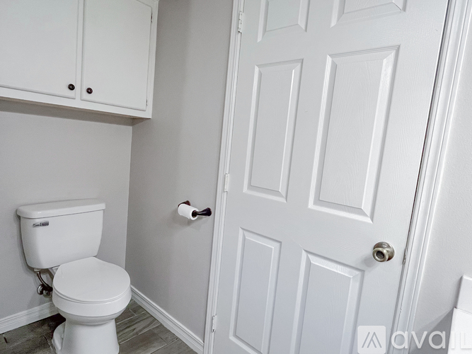 A white toilet in a bathroom with a white door.