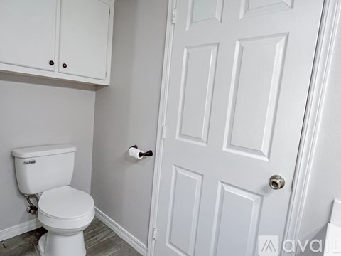 A white toilet in a bathroom with a white door.
