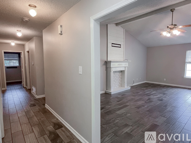 A spacious room with a fireplace and a ceiling fan.