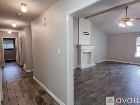 A spacious room with a fireplace and a ceiling fan.