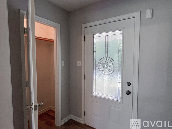 A white door with a glass window and a round design in the middle.