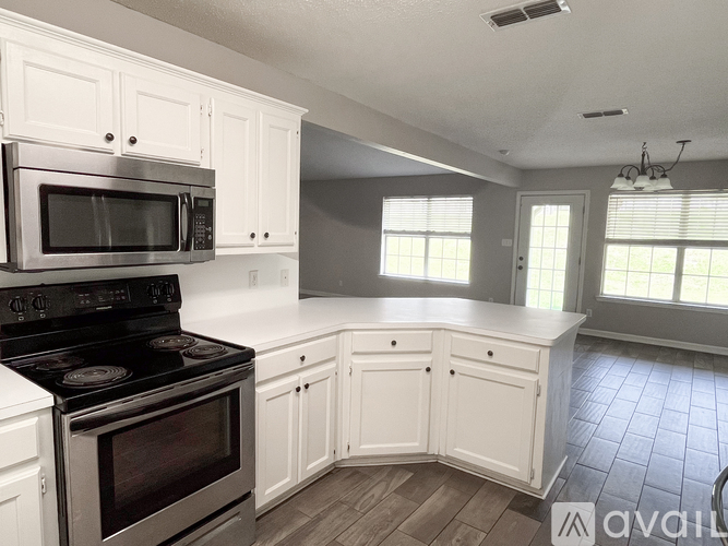 A kitchen with white cabinets and a black stove top oven.