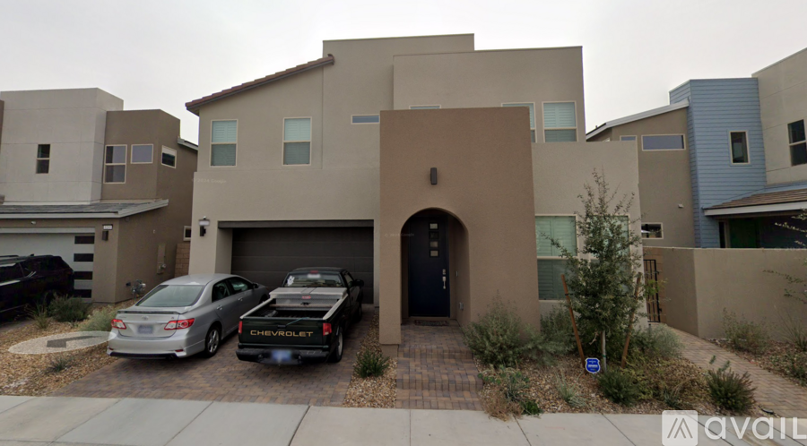 Two cars are parked in front of a house.