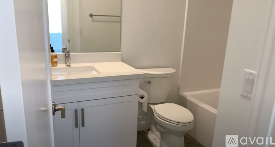 A white bathroom with a toilet, sink, and bathtub.